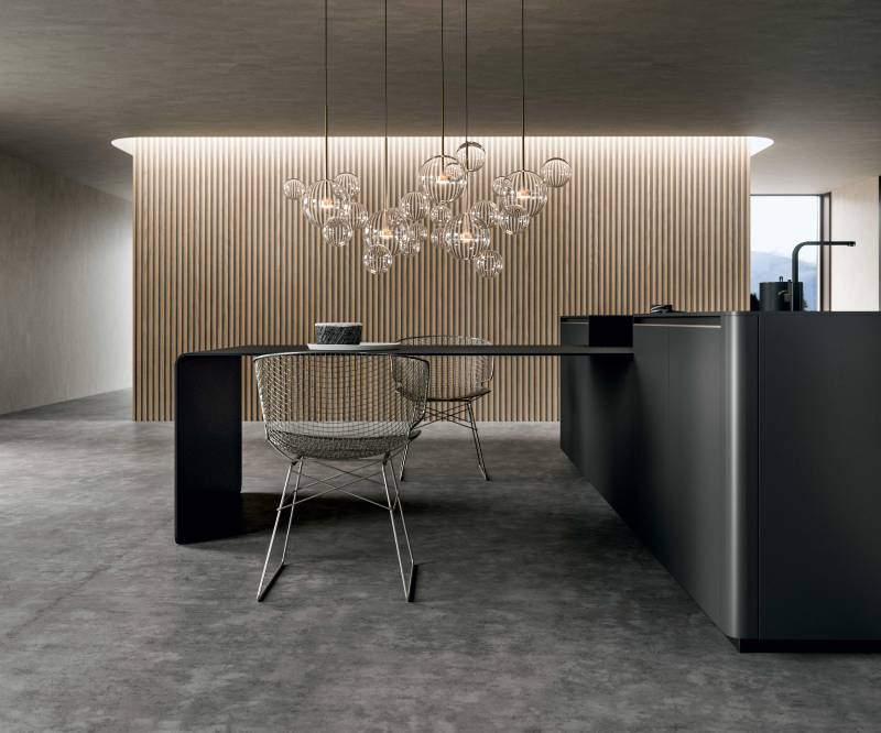 Boiserie 2+2 réalisée en mélaminé Papiro :  la ver ticalité du mur mis en relief par la  sinuosité de la table Brooklyn.